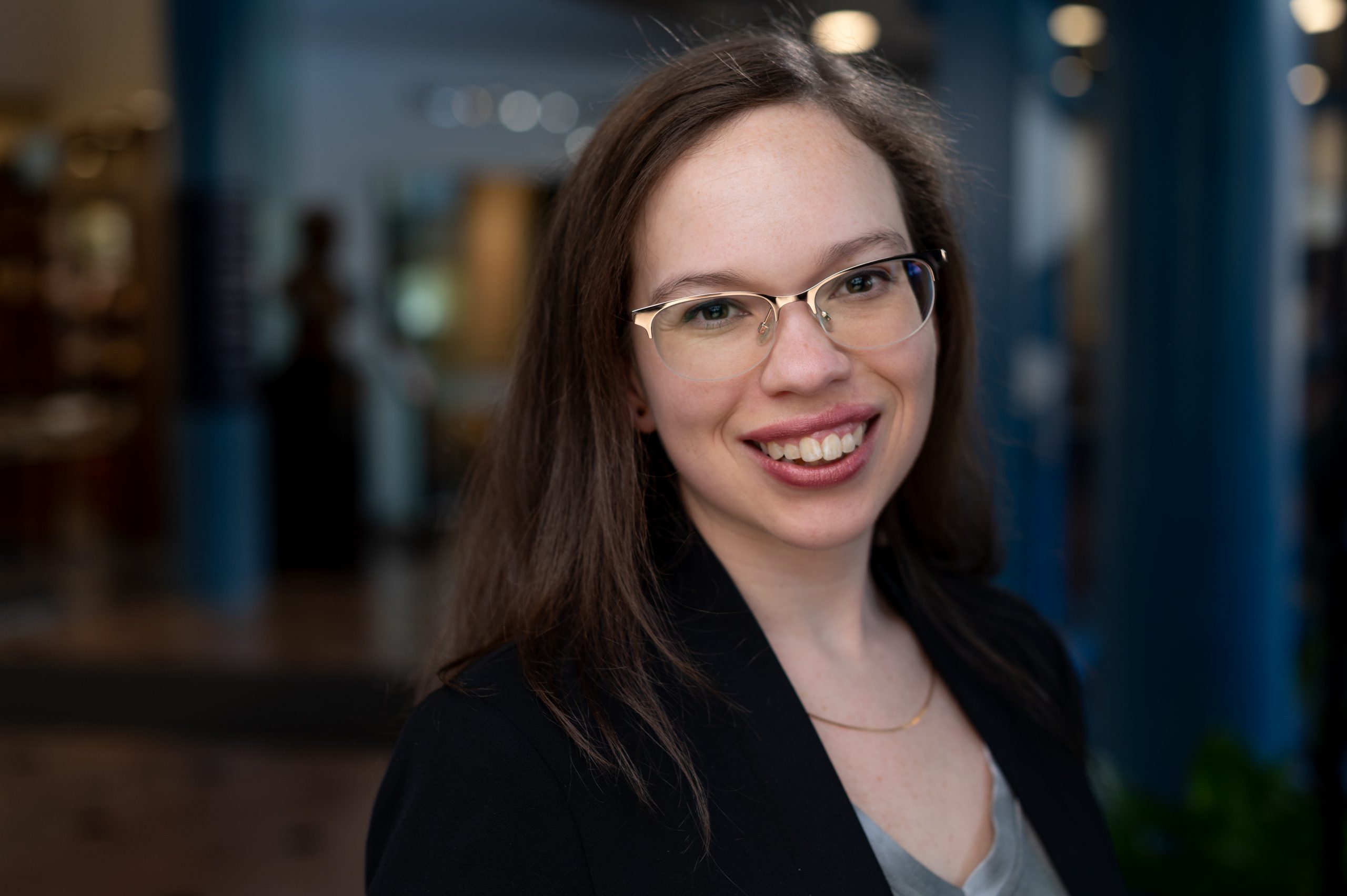 Alyssa Webb, a woman with glasses and long brown hair, smiles at the camera.